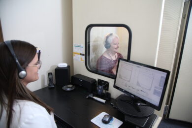 A female audiologist performing a test on an elderly patient